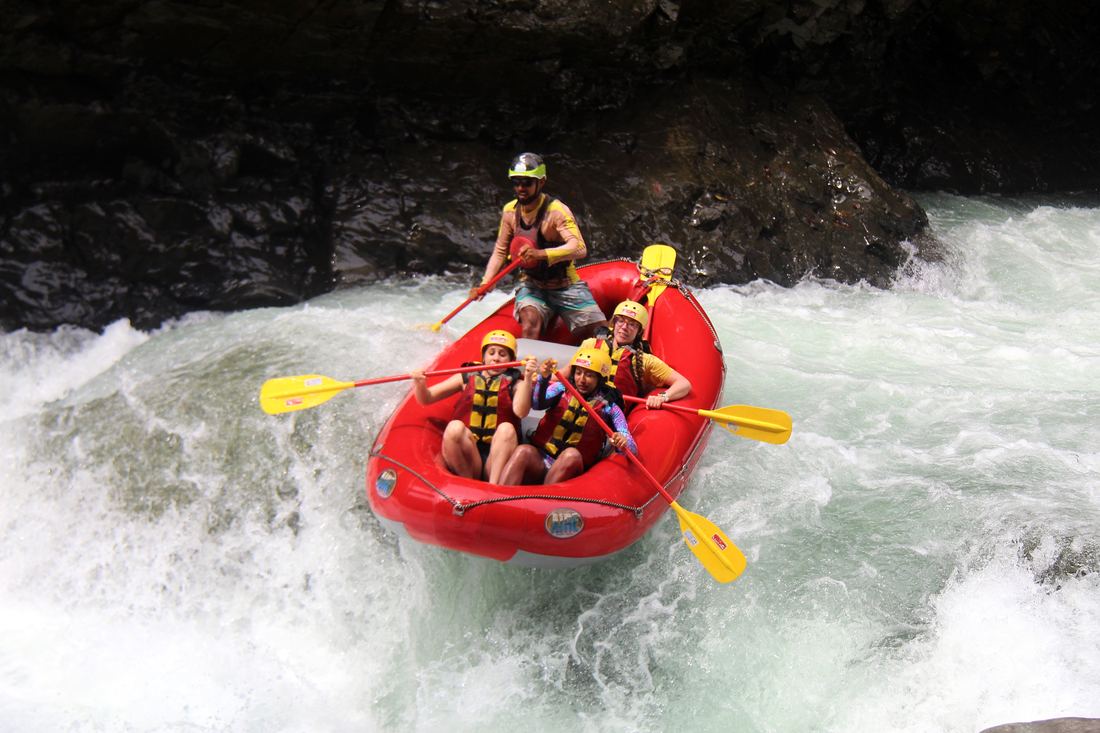 A raft dropping into a rapid between the canyon walls
