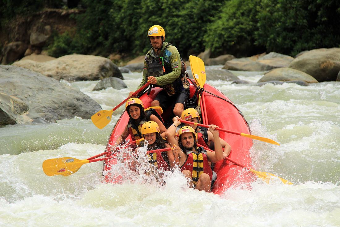 Guide and guests paddling through white water on the Naranjo
