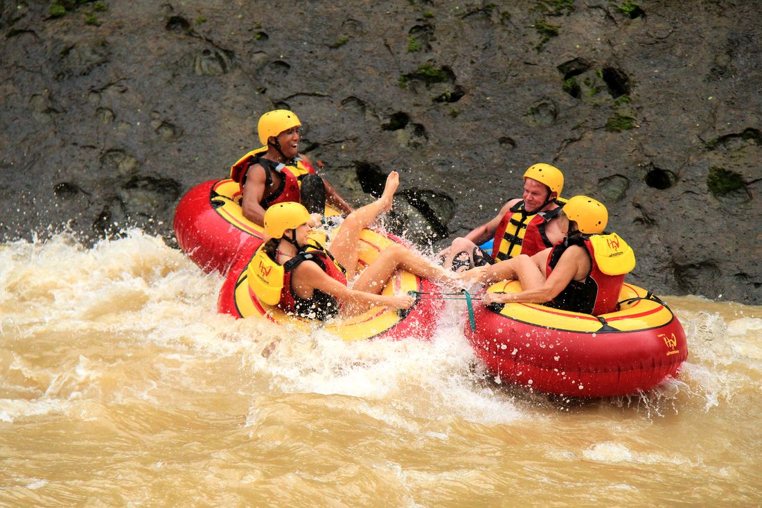 Tubers linked together riding a brown-water rapid