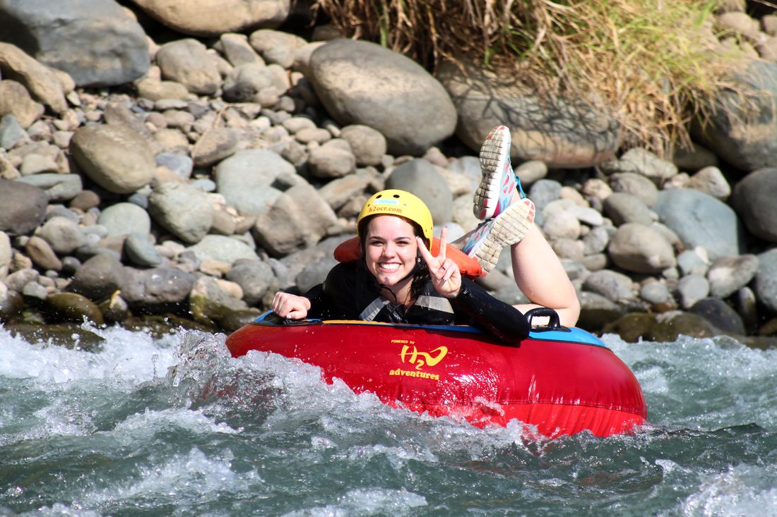A guest laughing with her feet up in a tube by the rocks
